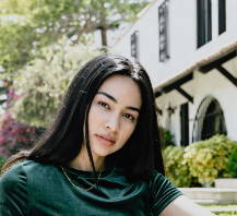 Woman sitting outside near greenery